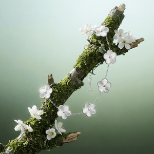 Flower Charm Bracelet displayed on a mossy branch, featuring elegant floral details that highlight beauty and femininity.