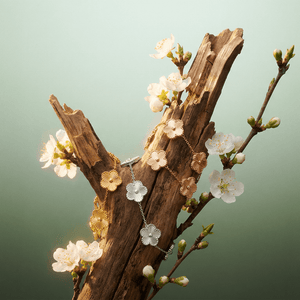 Flower Charm Bracelet displayed with floral accents on a decorative wooden branch.
