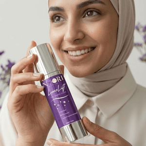 Woman holding Luna Lift Facial Serum with a smile, showcasing its halal-certified skin lifting benefits.