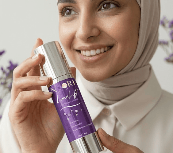 Woman holding Luna Lift Facial Serum with a smile, showcasing its halal-certified skin lifting benefits.